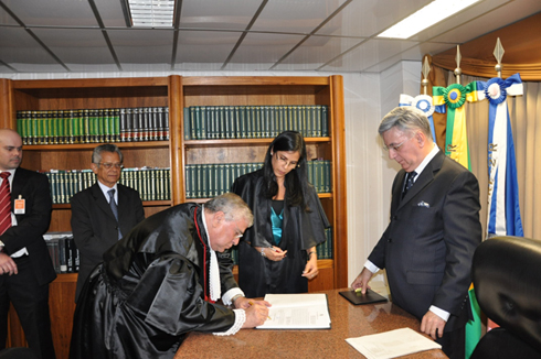 França Neto assina o termo de posse diante do presidente do TRF2 (à direita)