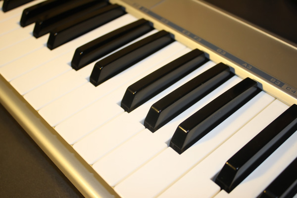 Imagem em diagonal das teclas de um piano, começando no canto superior à esquerda e terminando no canto inferior à direita.