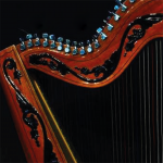 Fundo preto. Foto da parte superior de uma harpa de madeira com entalhes pretos.