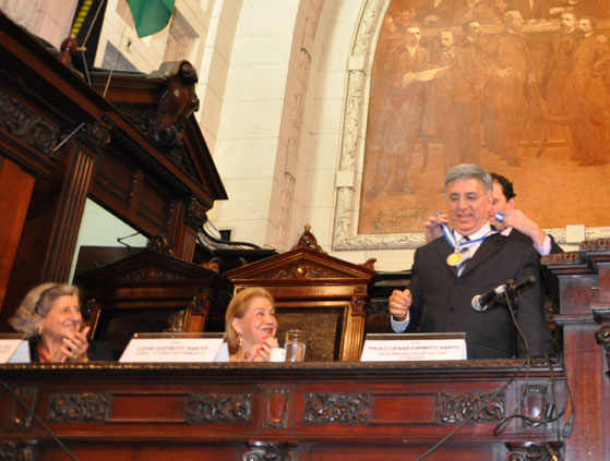 André Lazaroni apõe a comenda no homenageado observado por Salete Maccaloz e Leise Espirito Santo