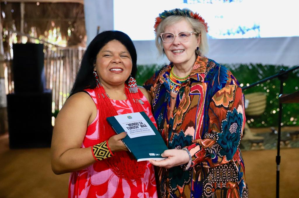 A ministra dos Povos Indígenas Sônia Guajajara e a ministra Rosa Weber posam segurando a Constituição Federal