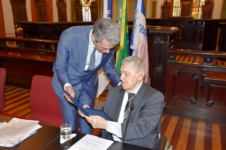 Guilherme Calmon entrega placa comemorativa do TRF2 ao convidado de honra Paulo Barata para condecorar toda a sua trajetória e atuação jurídica e administrativa.