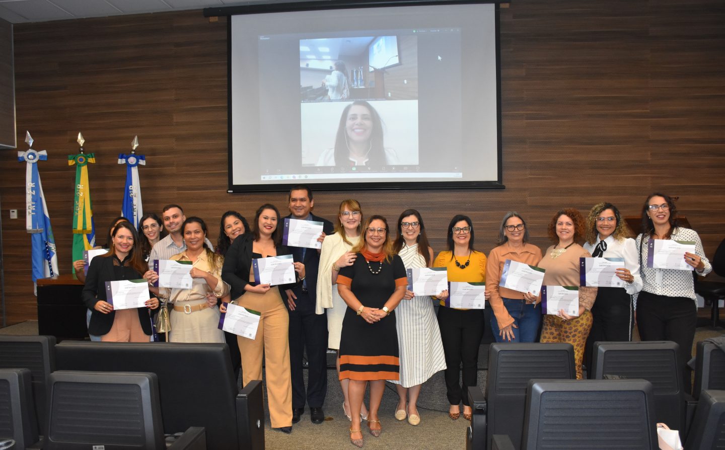 Alunos da Escola de Mediação do TRF2 segurando seus certificados de conclusão do Curso de Formação de Conciliadores e Mediadores Judiciais